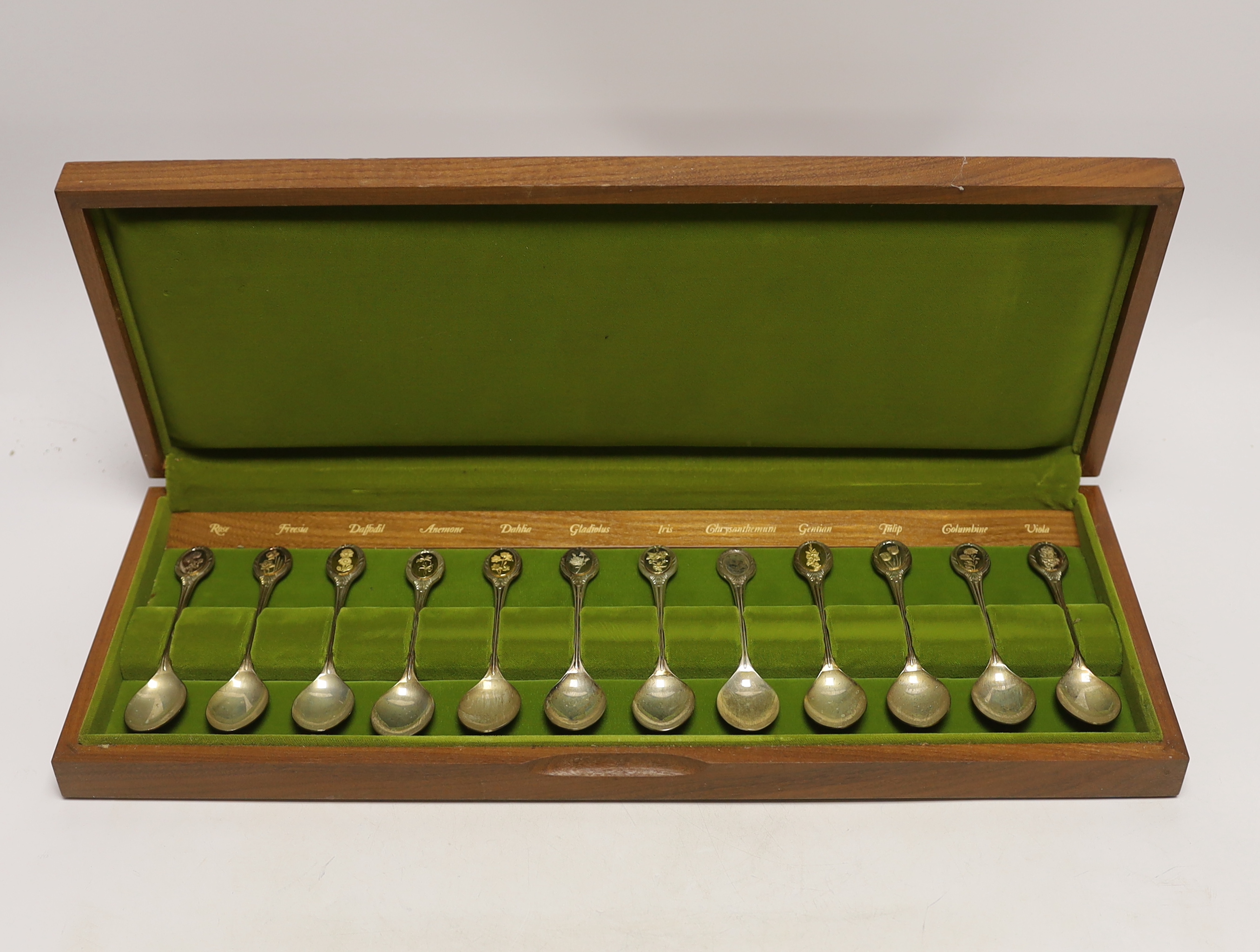 A modern cased set of twelve parcel gilt silver 'Royal Horticultural Society Flower Spoons' by John Pinches, with cert, 9.5oz.